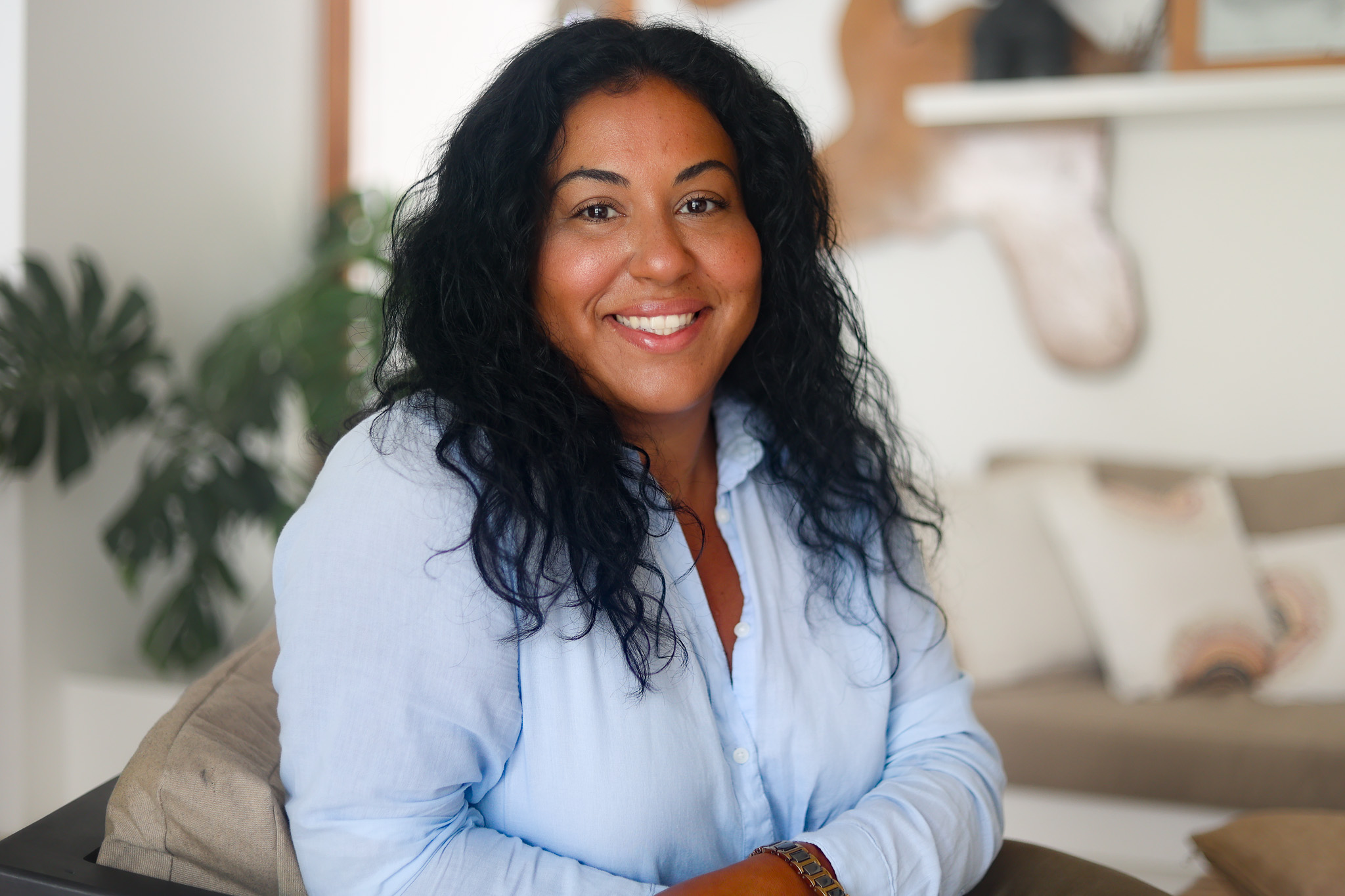 Lynnette Diaz smiling, seated in a warm therapy office